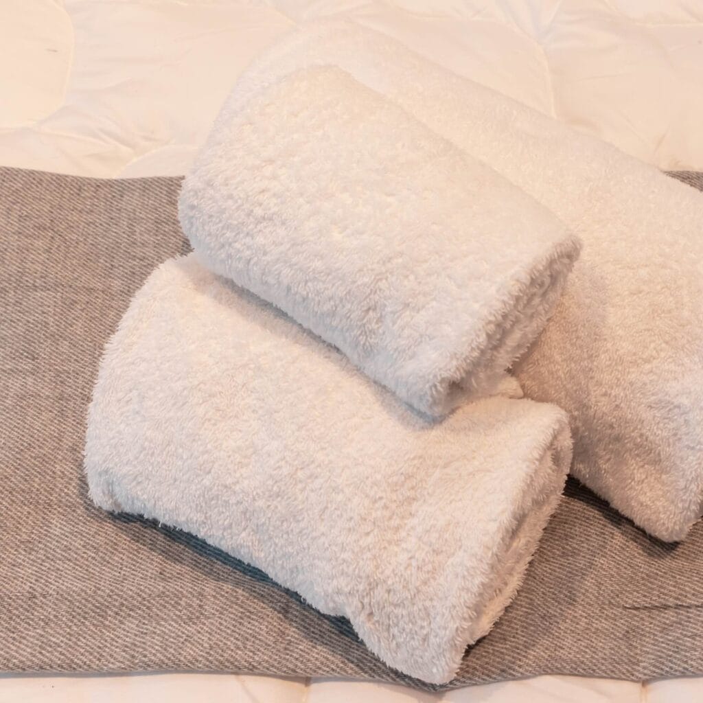 Dettaglio di una camera a Roma con tovaglie per bagno piegate sul letto