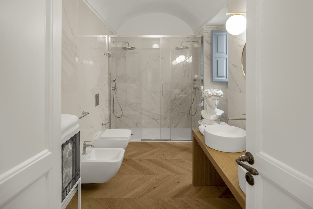 Panoramica del bagno dell'elegante suite Nora con doccia doppia, lavandino, bidet e wc