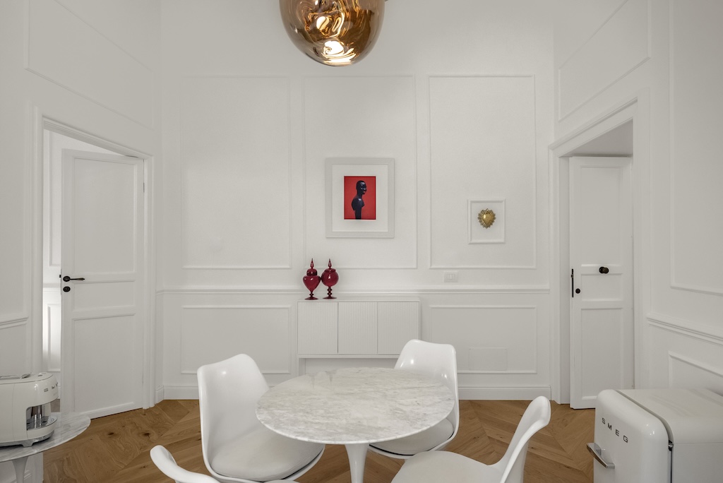 Dettaglio della zona giorno dell'elegante suite Laura con tavolino, sedie e design artistico