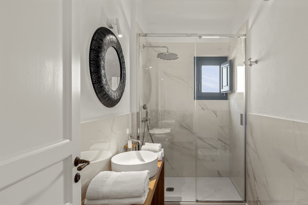 Dettaglio del bagno dell'elegante suite Christine con doccia, lavandino e specchio