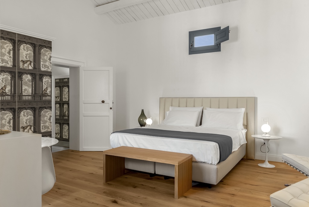 Dettaglio della camera da letto della suite Carla con letto, comodini e lampade