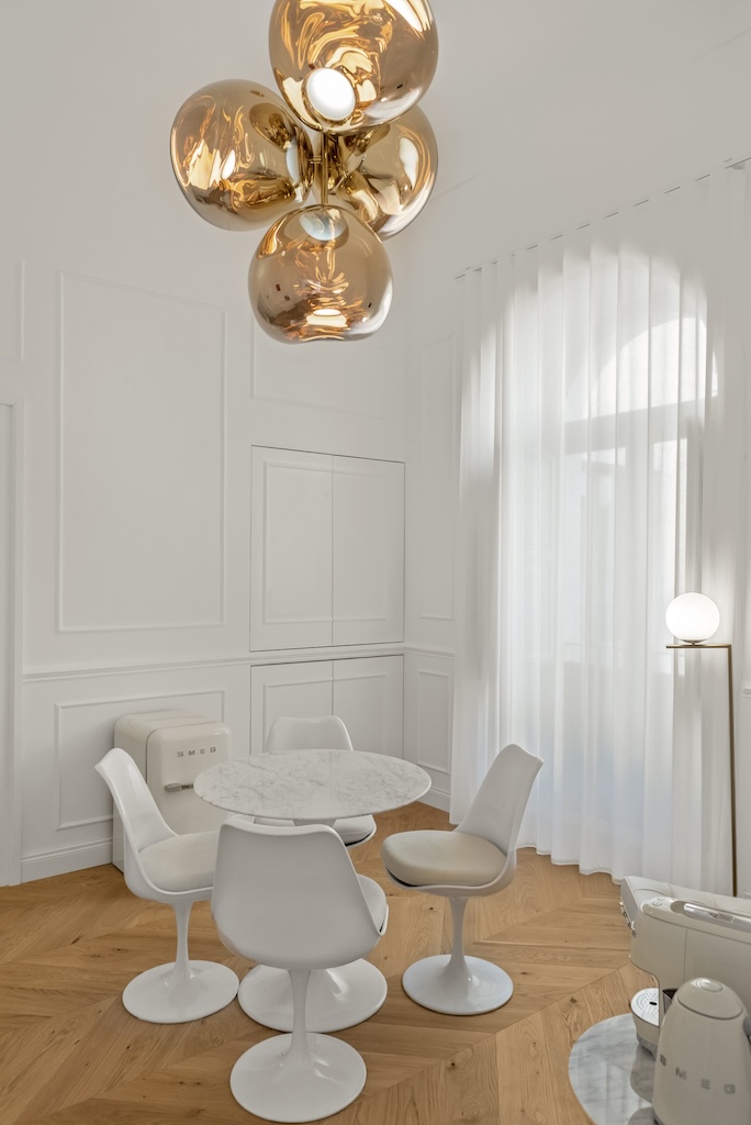 Dettaglio del soggiorno dell'elegante suite Christine con tavolino, sedie, macchina del caffè e bollitore e design artistico